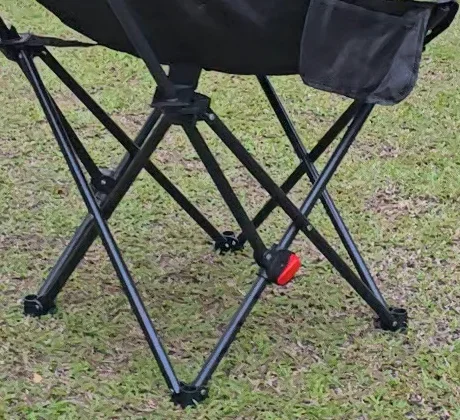 Closer view of the black chair’s lower frame, feet and red adjustment hardware.